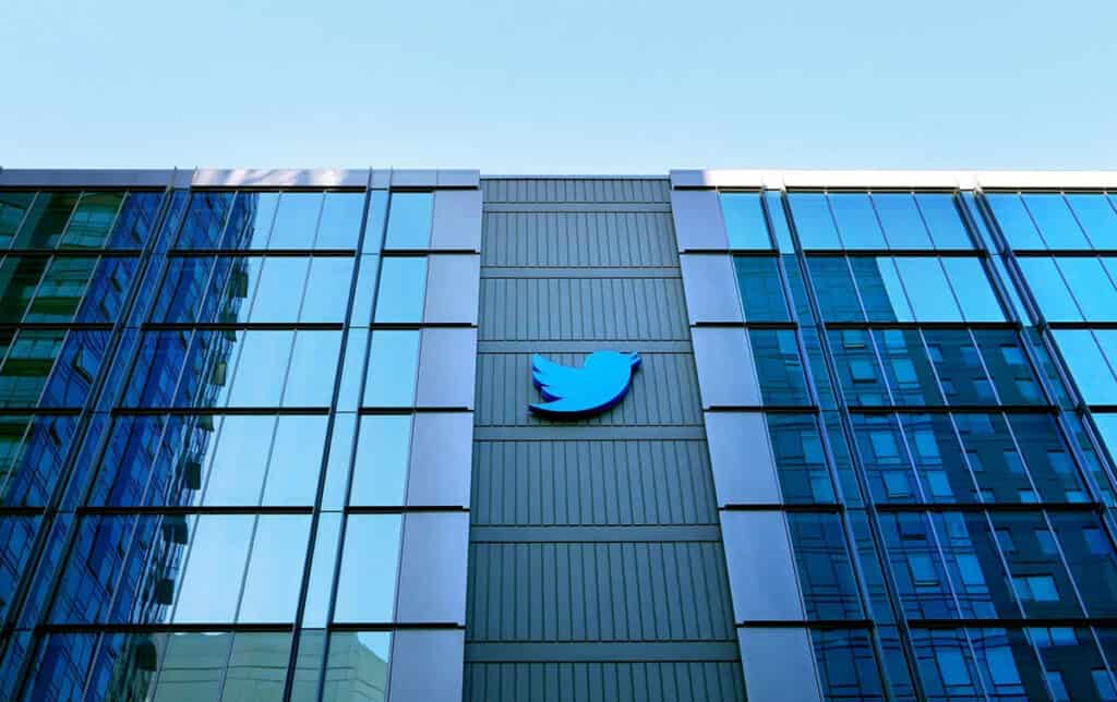 Twitter logo displayed on the exterior of a modern office building with glass facade and corporate architecture.