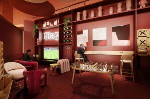 Modern gaming lounge interior with chess table, console gaming area, and stylish seating in a premium social space.