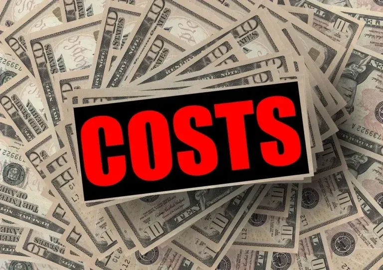 Word “COSTS” in bold red letters over scattered dollar bills, representing expenses and financial impact.